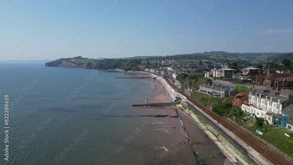 Dawlish, South Devon, England: DRONE VIEWS: The coastline at Dawlish featuring the railway track and station, the beach, sea, houses and town quay. Dawlish is a popular UK holiday resort (Clip 3). Dawlish, South Devon, England: DRONE VIEWS: The coastline at Dawlish featuring the railway track and station, the beach, sea, houses and town quay. Dawlish is a popular UK holiday resort (Clip 3).