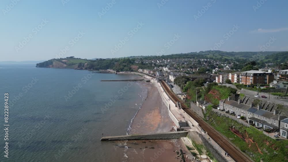 Dawlish, South Devon, England: DRONE VIEWS: The coastline at Dawlish featuring the railway track and station, the beach, sea, houses and town quay. Dawlish is a popular UK holiday resort (Clip 2). Dawlish, South Devon, England: DRONE VIEWS: The coastline at Dawlish featuring the railway track and station, the beach, sea, houses and town quay. Dawlish is a popular UK holiday resort (Clip 2).