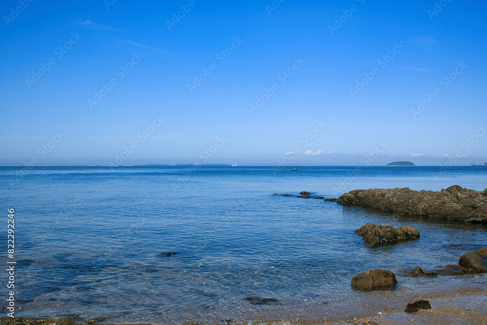ゴツゴツした岩の潮溜りの透き通った青い海