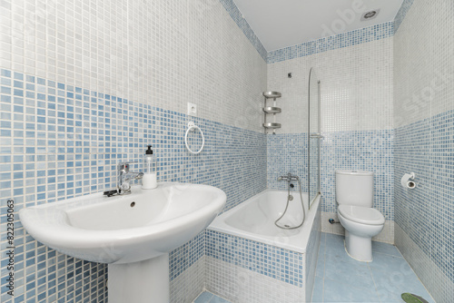 A bathroom with blue gresité-type tiles and white porcelain toilets
