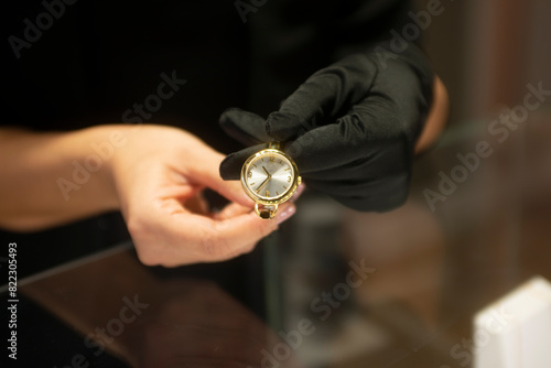 Woman's hands showing female wristwatches on display in a store