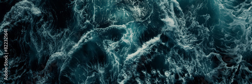 Aerial view of turbulent ocean waves, with foamy crests and swirling water, capturing the raw power and dynamic movement of the sea.