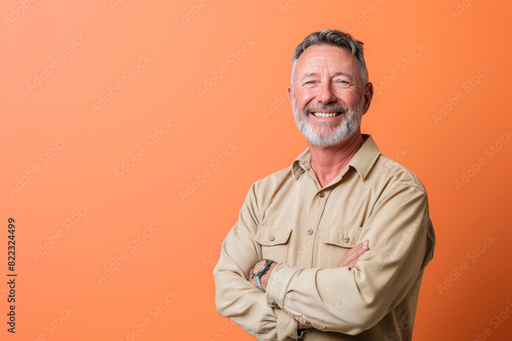 Smiling Mature Man in Khaki Shirt with Folded Arms Smiling Mature Man in Khaki Shirt with Folded Arms