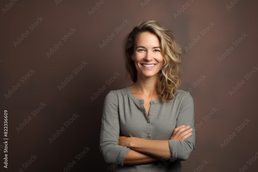 Portrait of a happy woman in her 30s with arms crossed in plain cyclorama studio wall Portrait of a happy woman in her 30s with arms crossed in plain cyclorama studio wall