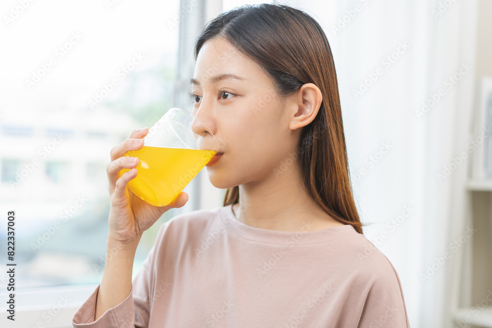 Asian young woman drinking, hand holding a glass of water after putting or dropping yellow effervescent tablet, painkiller medicine, aspirin for treatment, take vitamin c for hangover, health care. Asian young woman drinking, hand holding a glass of water after putting or dropping yellow effervescent tablet, painkiller medicine, aspirin for treatment, take vitamin c for hangover, health care.
