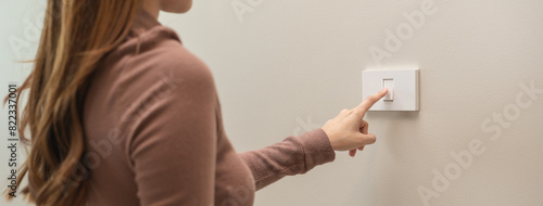 Foto Asian young woman hand turn off on lighting switch at home room