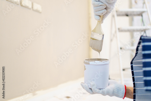 Woman painting the wall at home.