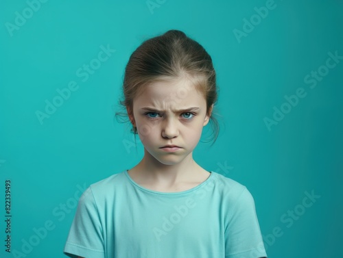 Turquoise background sad European white child realistic person portrait of young beautiful bad mood expression child Isolated on Background depression anxiety fear 