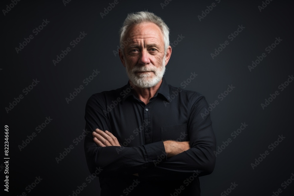 Portrait of a blissful man in his 60s with arms crossed on plain cyclorama studio wall Portrait of a blissful man in his 60s with arms crossed on plain cyclorama studio wall