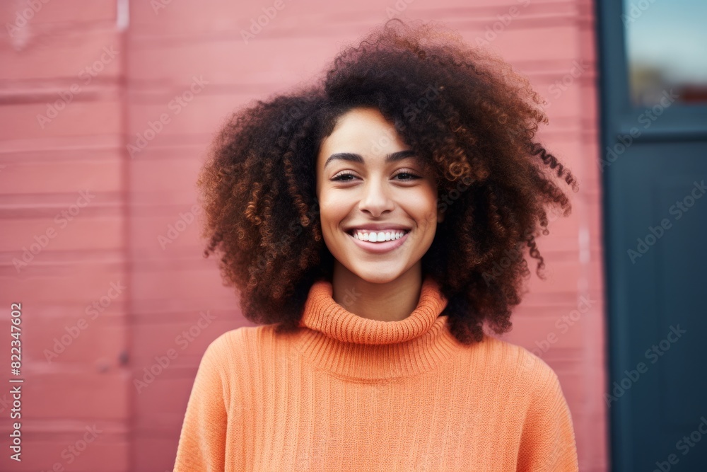 Portrait of a blissful afro-american woman in her 20s smiling at the camera in front of plain cyclorama studio wall Portrait of a blissful afro-american woman in her 20s smiling at the camera in front of plain cyclorama studio wall