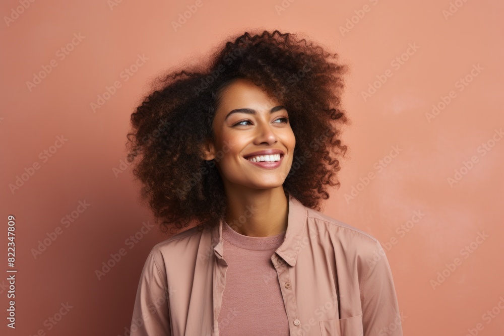 Portrait of a blissful afro-american woman in her 20s smiling at the camera isolated in plain cyclorama studio wall Portrait of a blissful afro-american woman in her 20s smiling at the camera isolated in plain cyclorama studio wall