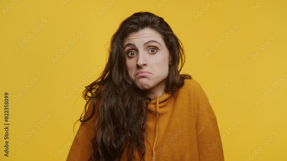 Confused Woman Shrugging on Yellow Background Confused Woman Shrugging on Yellow Background