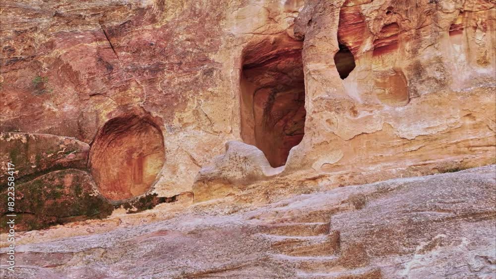 Small opening in sandstone leading to cave dwellings in Petra or Raqmu, an ancient stone city of the Nabataeans. Jordan Small opening in sandstone leading to cave dwellings in Petra or Raqmu, an ancient stone city of the Nabataeans. Jordan
