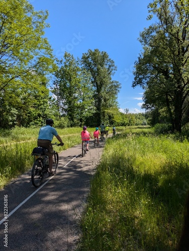 View of Via Rhona with distant cyclists, beautiful spring day with blue sky and lush nature, Belley, France 