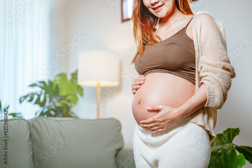 birth, motherhood, child, pregnant, parenting, prenatal, parenthood, pregnancy, mother, life. A woman is pregnant and is holding her stomach. She is wearing a brown top and white pants. Free Download birth, motherhood, child, pregnant, parenting, prenatal, parenthood, pregnancy, mother, life. A woman is pregnant and is holding her stomach. She is wearing a brown top and white pants. - GFXLoad