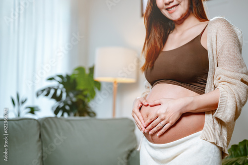 mother, happiness, pregnancy, family, abdomen, motherhood, happy, parenthood, pregnant, prenatal. A woman is holding her stomach and making a heart shape with her fingers. She is smiling and happy. Free Download mother, happiness, pregnancy, family, abdomen, motherhood, happy, parenthood, pregnant, prenatal. A woman is holding her stomach and making a heart shape with her fingers. She is smiling and happy. - GFXLoad