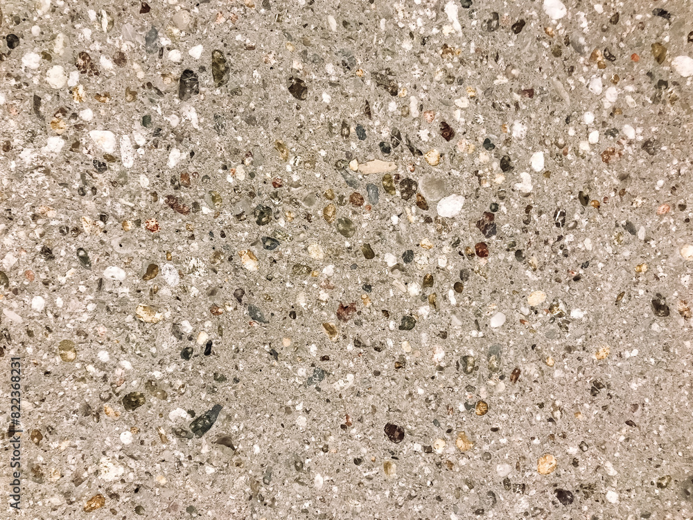 A grey and white stone surface with many small rocks scattered across it A grey and white stone surface with many small rocks scattered across it
