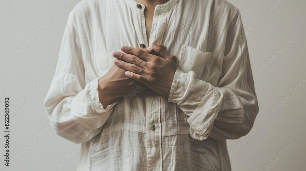 Photo of a person clutching their chest in distress against a white backdrop