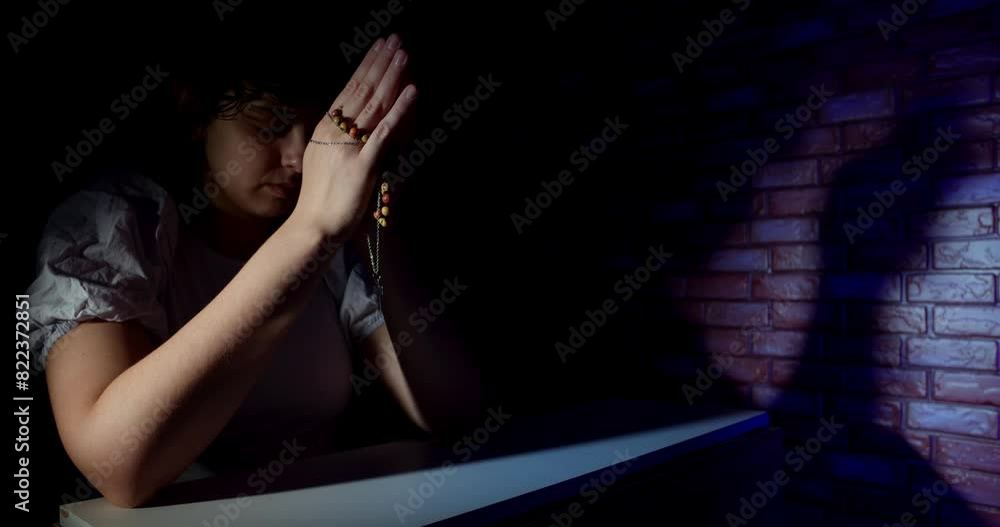 Young Woman Praying In The Dark At Home Young Woman Praying In The Dark At Home