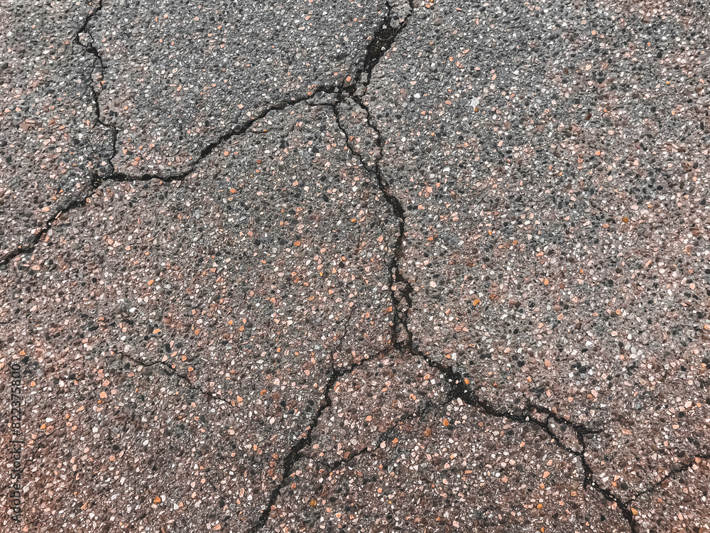 Fototapeta premium A cracked and broken road with a lot of gravel