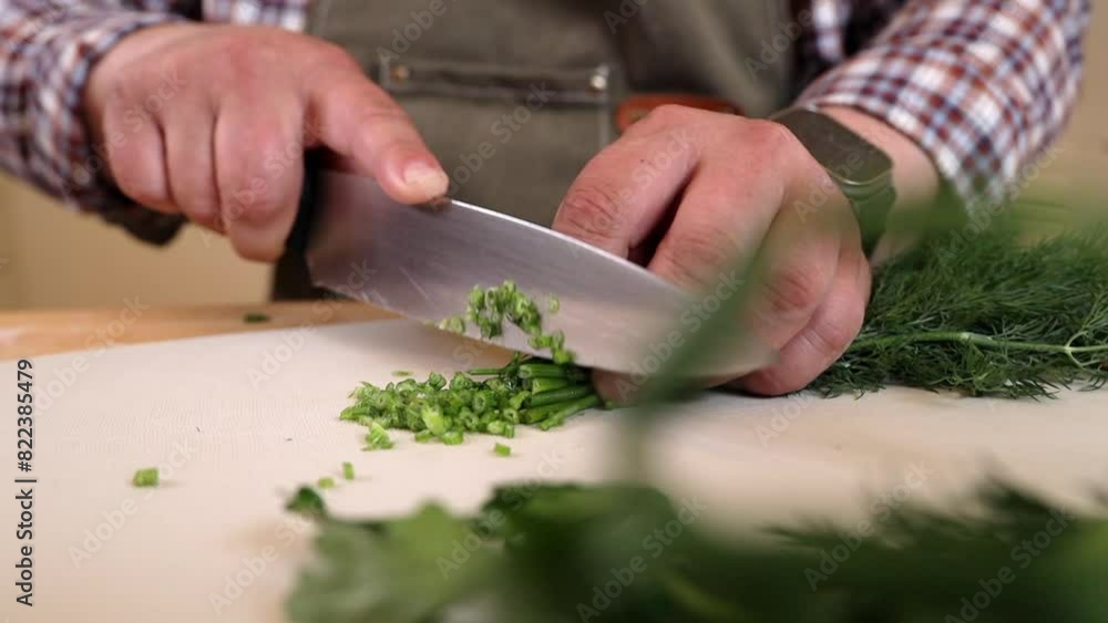 a male chef chopping greens on a chopping board a male chef chopping greens on a chopping board