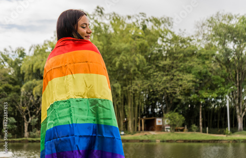 adolescente hispano latina con la bandera del arco iris en el mes del orgullo gay  photo
