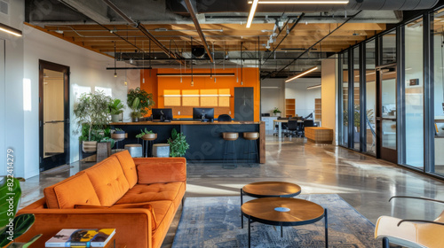 A large open office space with a couch, two coffee tables, and a potted plant