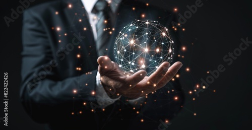 Businessman holding a virtual glowing connection sphere with network dots and lines in his hand on a dark background, representing a technology concept for global business Generative AI