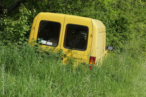 Fahrzeug wurde auf einer Wiese abgestellt und ist mit Gras eingewachsen photo