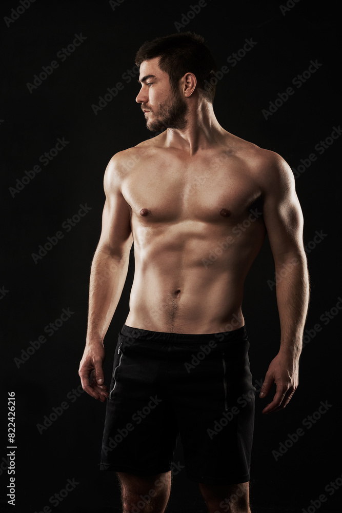 Naklejka premium Fitness, health and man shirtless for strong body, sports and cardio training isolated in studio. Male person, bodybuilder and abs from balance exercise and core workout with dark background