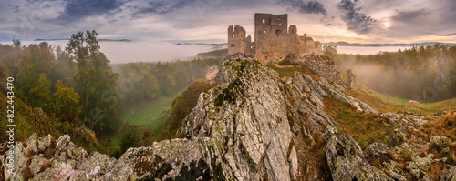 Autumn colorful foggy and mistical morning at sunrise. Typical autumn atmosphere with an old castle ruin in the background. Rocks and a fortified castle ruin. Hrusov castle near Topolcianky photo