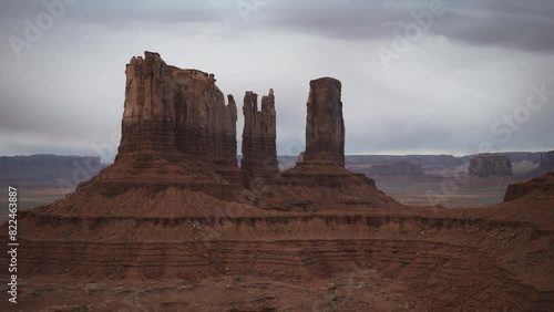 Aerial flyover panning shot of Bear and Rabbit and King on his Throne rock formations / Monument Valley, Utah, United States photo