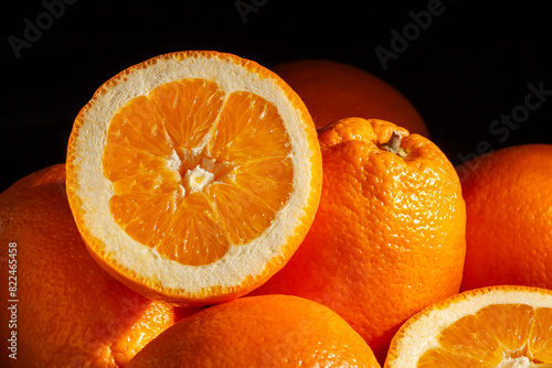 sliced calabrian oval blond oranges on black background photo