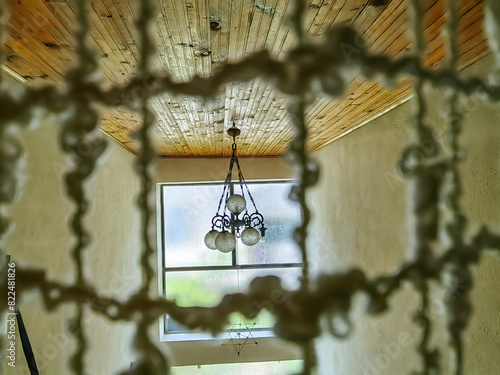 Timeless Elegance. An Old Chandelier Framed by Knots  in Interior Design.  photo