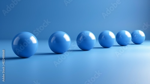  A line of blue balls aligns on a light blue surface  surrounded by a light blue wall in the background