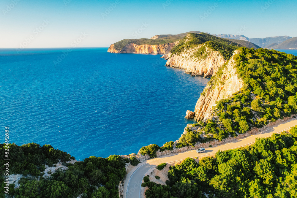 Obraz premium Lighthouse on the cliff. Seascape of Cape Lefkatas with old lighthouse on Lefkada island, Greece. Beautiful views of azure sea water and nature with cliffs