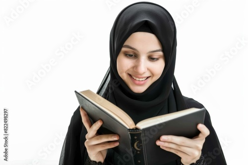 Young woman in hijab reading a book and smiling on a white background