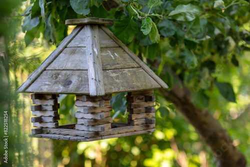 Handcrafted Wooden Birdhouse Hanging in Lush Green Garden during Daytime, Close-up of Rustic Design, Nature and Wildlife Habitat, Outdoor Leisure, Eco-friendly Gardening Concept © Bartek