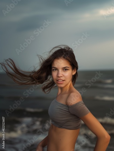 A young brunette woman jogging in nature looks at the camera and smiles. Active lifestyle. Health and beauty.