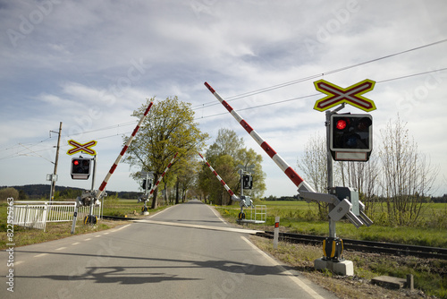 Railway crossing with closing barriers and lit red lights
