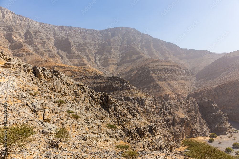 Jebel Jais mountain range, barren rocky peaks seen from Hidden Oasis village trail, United Arab Emirates. Jebel Jais mountain range, barren rocky peaks seen from Hidden Oasis village trail, United Arab Emirates.