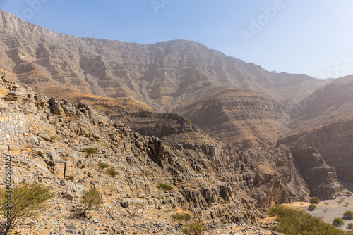 Jebel Jais mountain range, barren rocky peaks seen from Hidden Oasis village trail, United Arab Emirates.
