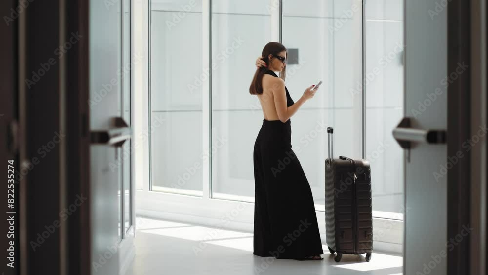 Business, stylish woman in black clothes with phone in hands, hurries to board a plane with a bag, airport terminal, Dubai, luxury and money, Emirates, success, confidence, hotel, lobby, check in Business, stylish woman in black clothes with phone in hands, hurries to board a plane with a bag, airport terminal, Dubai, luxury and money, Emirates, success, confidence, hotel, lobby, check in