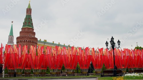 Side view of group of red flags with russian word Victory stands by Moscow Kremlin during Victory Day celebration in a cloudy spring day. Corner Arsenalnaya tower of Moscow Kremlin in the background. photo