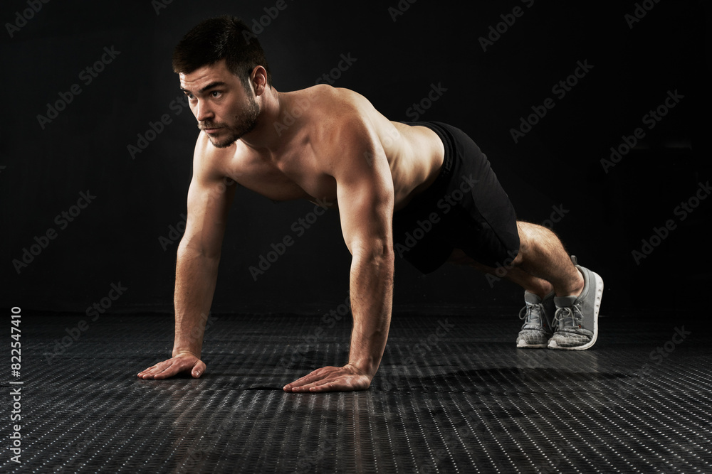 Muscular man, fitness and workout with push ups for exercise, studio or training on a black background. Active male person or bodybuilder lifting body weight with arms on floor for muscle gain at gym Muscular man, fitness and workout with push ups for exercise, studio or training on a black background. Active male person or bodybuilder lifting body weight with arms on floor for muscle gain at gym