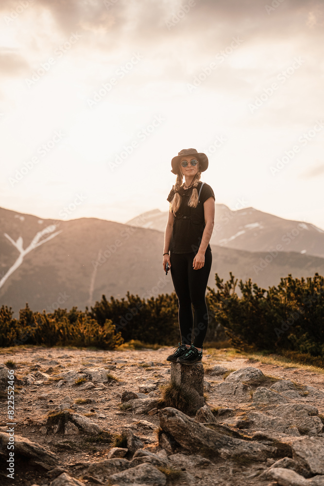 Obraz premium Young traveler hiking girl with backpacks. Hiking in mountains. Tourist traveler. Hiking in Slovakia mountains landscape. Low Tatras national park, Slovakia.