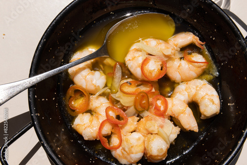 Garlic shrimp with butter and topped with chiles served in a cast iron pan in Portugal. 