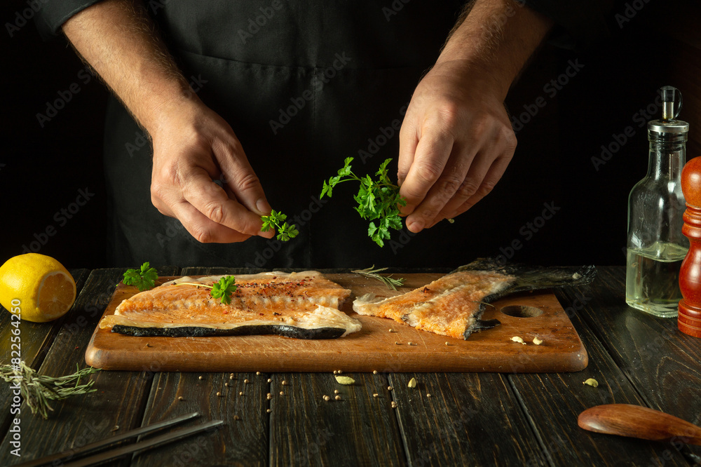The chef prepares fresh red fish on the kitchen table in the hotel. Before frying, fish steaks are seasoned with aromatic herbs. Asian cuisine. The chef prepares fresh red fish on the kitchen table in the hotel. Before frying, fish steaks are seasoned with aromatic herbs. Asian cuisine.