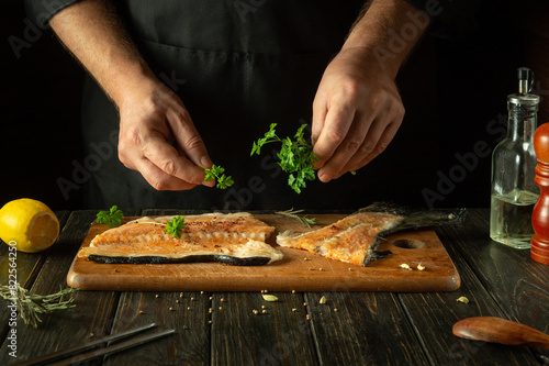 The chef prepares fresh red fish on the kitchen table in the hotel. Before frying, fish steaks are seasoned with aromatic herbs. Asian cuisine.