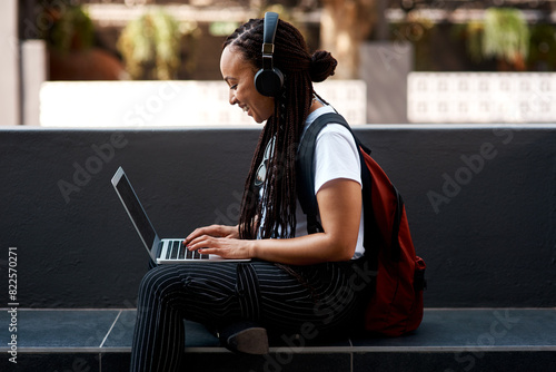 Woman, student and headset with laptop outside, typing and online classes for elearning or education. University, learner and website research for assignment, listening and podcast or school project